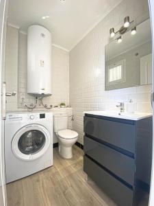 a bathroom with a washing machine and a toilet at Small Oasis Nelson Mandela Apartment with sea view, two bedrooms, parking, terrace and pool in Manilva