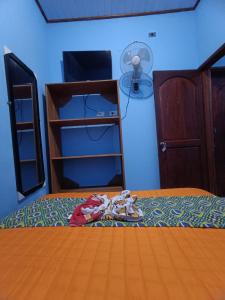 a bedroom with a bed with a fan and a closet at Residencia Grecia in Leticia