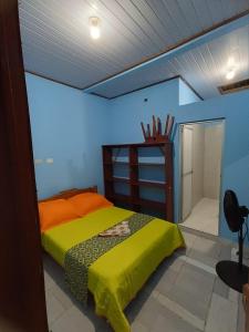 a bedroom with a bed in a blue room at Residencia Grecia in Leticia