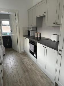 a kitchen with white cabinets and a black counter top at 14 crouch road in Burnham on Crouch