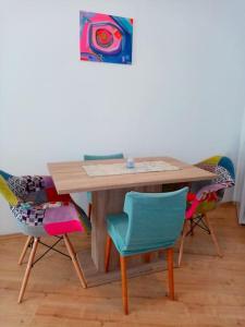 a wooden table with chairs and a painting on the wall at Lovely Studio in Old Town in Labin