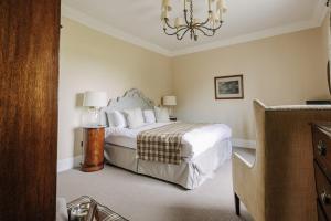 a bedroom with a bed and a chandelier at Victoria in Holkham