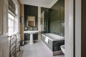 a bathroom with a tub and a sink and a bath tub at Victoria in Holkham