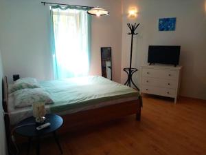 a bedroom with a bed and a television and a table at Lovely Studio in Old Town in Labin