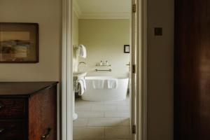 a bathroom with a white tub and a sink at Victoria in Holkham