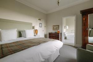 a bedroom with a large white bed and a bathroom at Victoria in Holkham