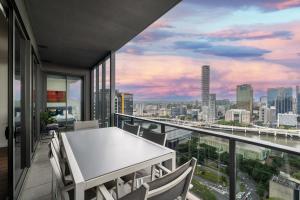 d'un balcon avec une table et des chaises offrant une vue sur la ville. dans l'établissement Multi Million River View 3BD Penthouse at SouthBank, à Brisbane