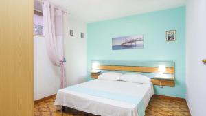 マリーナ・ディ・マンカヴェルサにあるVilletta Ischia by Salento Affittiのベッドルーム1室(白いベッド1台、青い壁付)