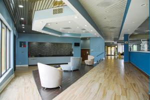 a lobby with white chairs and blue walls at My Homes Macon North I-75 By OYO in Macon
