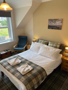 een slaapkamer met een bed met twee handdoeken erop bij No 4 Portpatrick B&B in Portpatrick