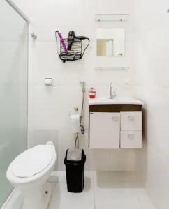 ein weißes Bad mit einem WC und einem Waschbecken in der Unterkunft Pousada Casa da Fernanda, Suíte Moon in Praia Grande