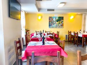 a dining room with tables and chairs with red table cloth at Hostal Ainoa in Berlanga de Duero