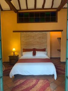 um quarto com uma cama grande num quarto em la posada del angel em Zipaquirá