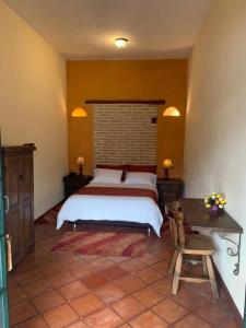 ein Schlafzimmer mit einem Bett und einem Tisch darin in der Unterkunft la posada del angel in Zipaquirá