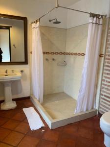 a bathroom with a shower with a sink and a toilet at la posada del angel in Zipaquirá