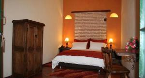 1 dormitorio con cama y pared de ladrillo en la posada del angel, en Zipaquirá
