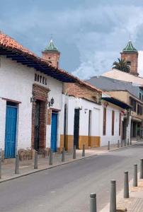 a street in a town with buildings with blue doors at la posada del angel in Zipaquirá