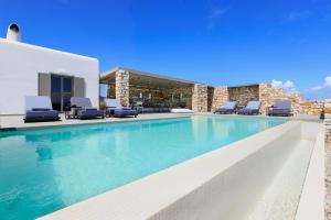 a swimming pool with blue water and lounge chairs at IL SOGNO VILLA 3 in Isterni