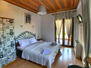 a bedroom with a large bed with white sheets at Hotel Apsis in Emporio