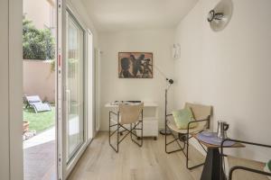 ein Wohnzimmer mit einem Tisch, Stühlen und einem Fenster in der Unterkunft La Piccola Corte - Sweet Dreams in Florence in Florenz