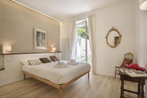 Schlafzimmer mit einem großen weißen Bett und einem Fenster in der Unterkunft La Piccola Corte - Sweet Dreams in Florence in Florenz