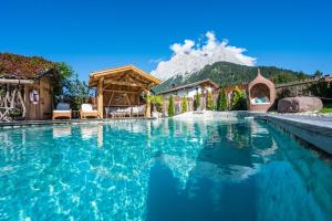 a swimming pool with a mountain in the background at Das Bucher in Ehrwald +22 photos