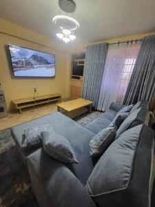 a living room with a couch and a tv at Blue House 2 Bedroom House. in Naivasha