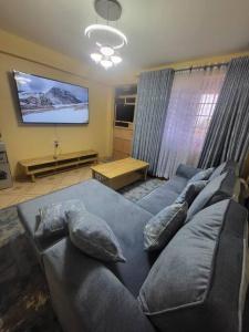 a living room with a couch and a tv at Blue House 2 Bedroom House. in Naivasha +2 photos
