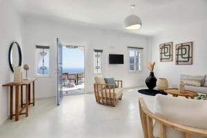 a white living room with a view of the ocean at Bluewhite Villa Santorini in Pyrgos
