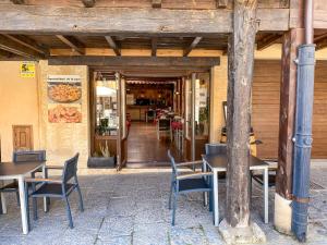 un restaurante con mesas y sillas frente a un edificio en Hostal Ainoa, en Berlanga de Duero