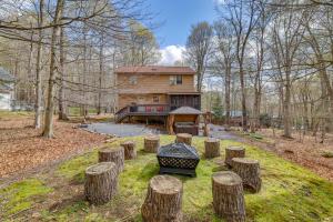 a house with a bunch of logs in front of it at Hot Tub and Game Room Cozy Big Bass Lake Home! in Gouldsboro