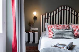 a bedroom with a bed with a black and white headboard at PUERTA DE ARMAS APARTMENTS in Seville