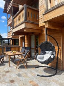 a wicker chair sitting on a patio in front of a house at Allure in Pirin Golf in Razlog +32 photos