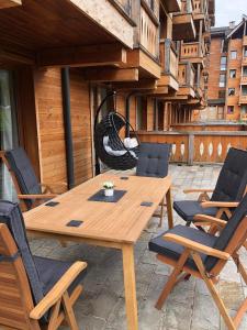 einen Holztisch und Stühle auf einer Terrasse in der Unterkunft Allure in Pirin Golf in Raslog