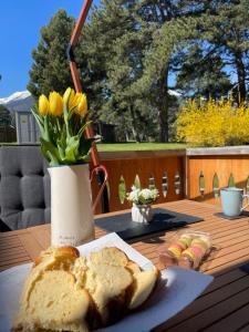 a table with a plate of bread and a vase of flowers at Allure in Pirin Golf in Razlog