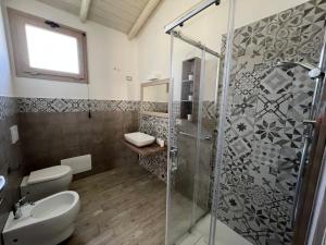 a bathroom with a shower and a toilet and a sink at Domus Deiana Case Vacanza in San Giovanni Suergiu