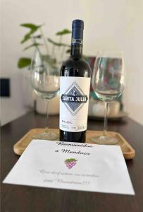 una botella de vino sentada en una mesa con dos copas en Moderno Departamento, en la mejor zona de Mendoza en Mendoza
