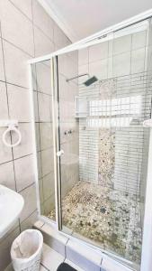 a shower with a glass door in a bathroom at Stylish Hartenbos Apartment in Mossel Bay