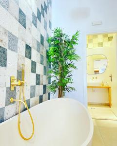 La salle de bains est pourvue d'une baignoire avec une plante. dans l'établissement Gerani Deluxe Houses, à Astypalée
