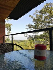 a glass on a table with a view of a field at Casa Pistacho in Santa Marta