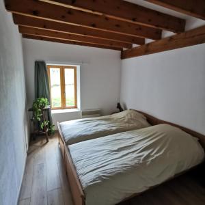 1 dormitorio con 2 camas y ventana en Auberge du Précontent, en Arfeuilles