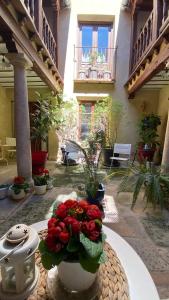 a vase of red flowers on a table in a courtyard at La Posada de Chinchilla in Chinchilla de Monte Aragón