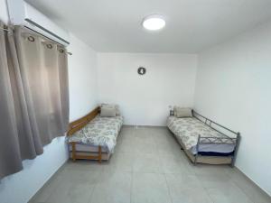 a room with two beds and a window at דירת נופש בבית שאן in Bet Sheʼan