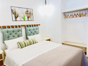 a bedroom with a white bed with a blue headboard at Gerani Deluxe Houses in Astypalaia