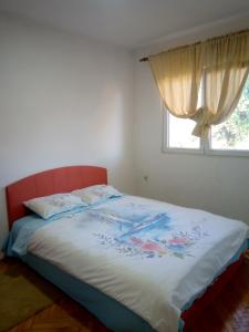 łóżko w sypialni z oknem w obiekcie Hostel Olea w mieście Podgorica