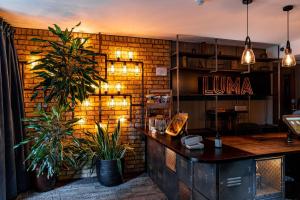 a bar with two potted plants in a room at Heeton Concept Hotel – Luma Hammersmith in London