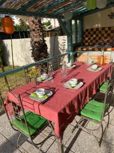 a table with a red table cloth on a table at Villa Hélios in Canet-en-Roussillon