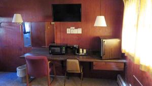 a kitchen with a desk with a microwave and a coffee maker at Indianhead Ironwood Hotel in Ironwood
