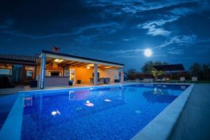 basen w nocy z księżycem na niebie w obiekcie Villa Absolute privacy w mieście Novigrad