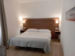 a bedroom with a large white bed with a wooden headboard at ROMANDRE in Alaior